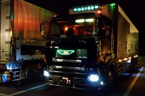 ライトが点灯した夜間のトラック